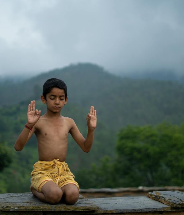 A person sitting in a calm meditation pose with a serene background.